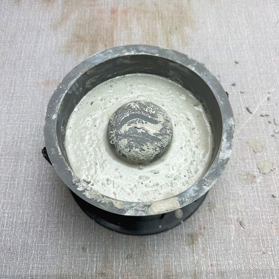 White concrete mix inside of a fire pit mold.