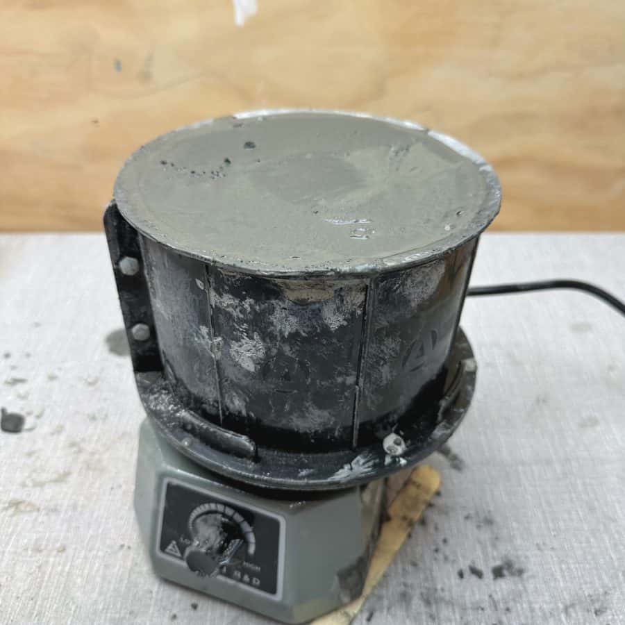 A concrete fire bowl mold on a vibrating machine.