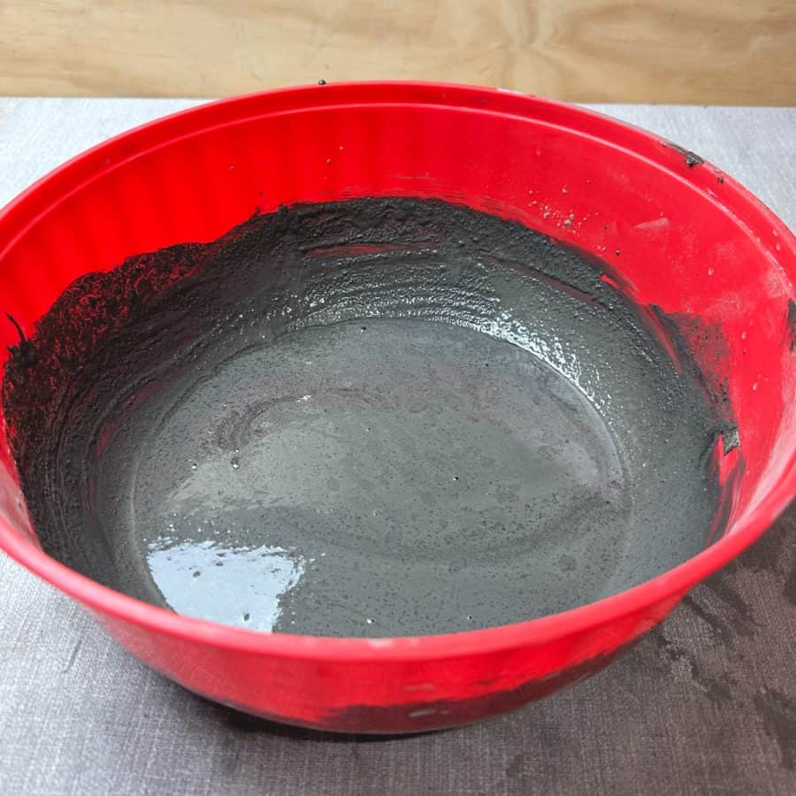 A wet cement mixture with black colorant.