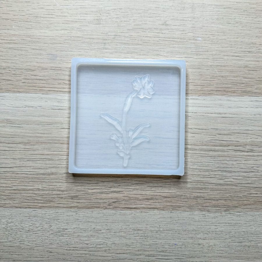 A concrete silicone mold with a silicone stamp pressed firmly against it.