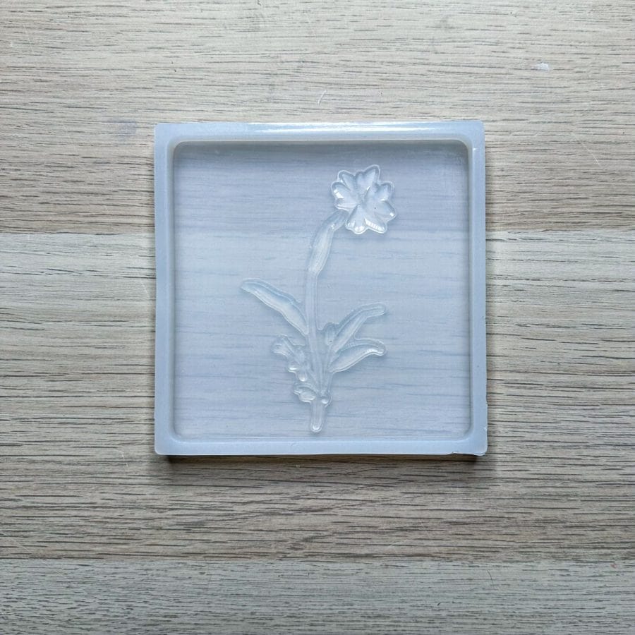A concrete silicone mold with a silicone stamp laying inside.