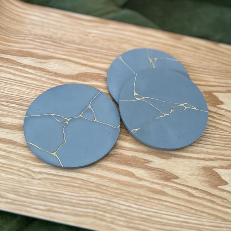 3 DIY concrete kintsugi coasters on a tray.