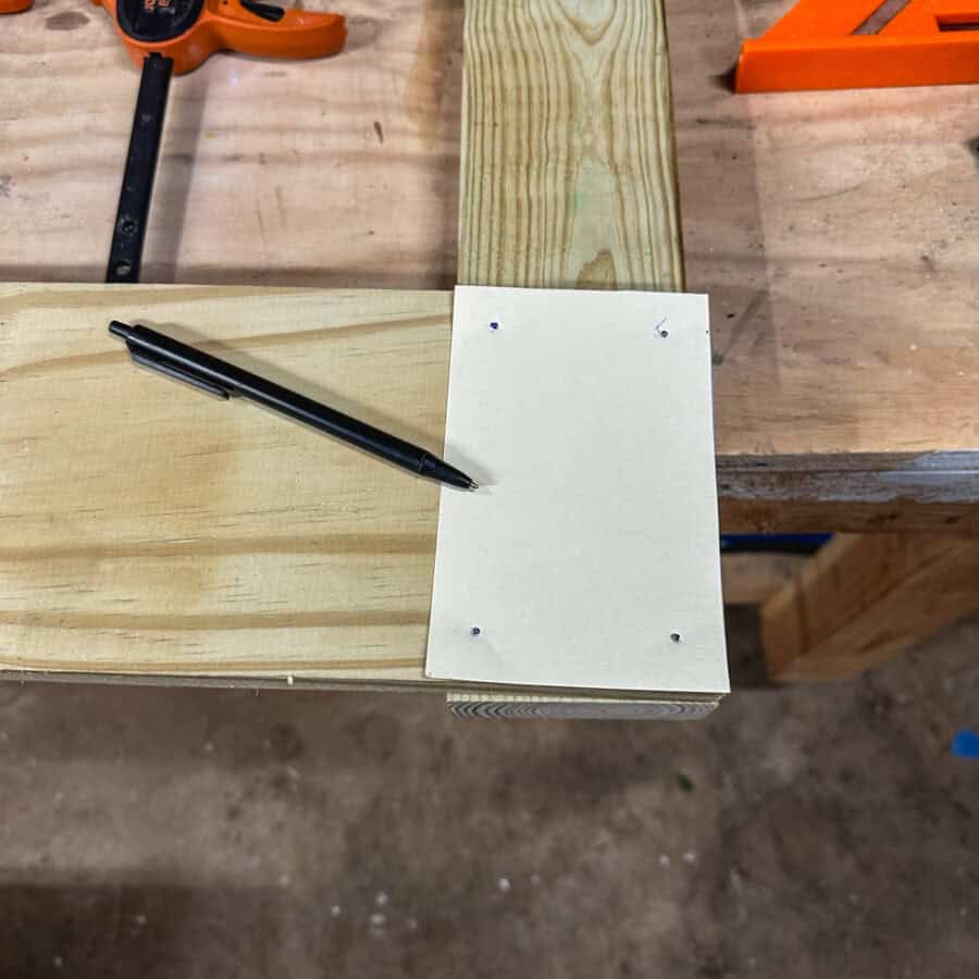 Card stock with 4 holes indicating where drill holes will go.