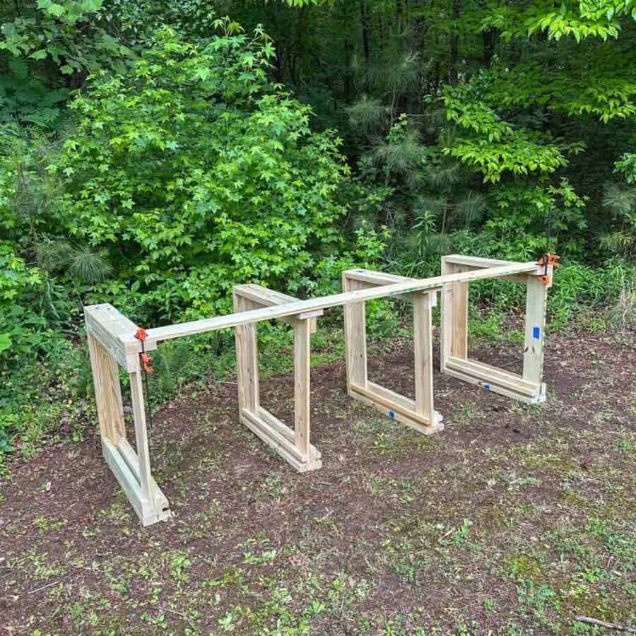 Legs of compost bins clamped to long boards.